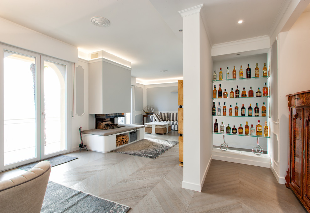 Пример оригинального дизайна: гостиная комната среднего размера в современном стиле с белыми стенами, светлым паркетным полом, угловым камином и фасадом камина из штукатурки