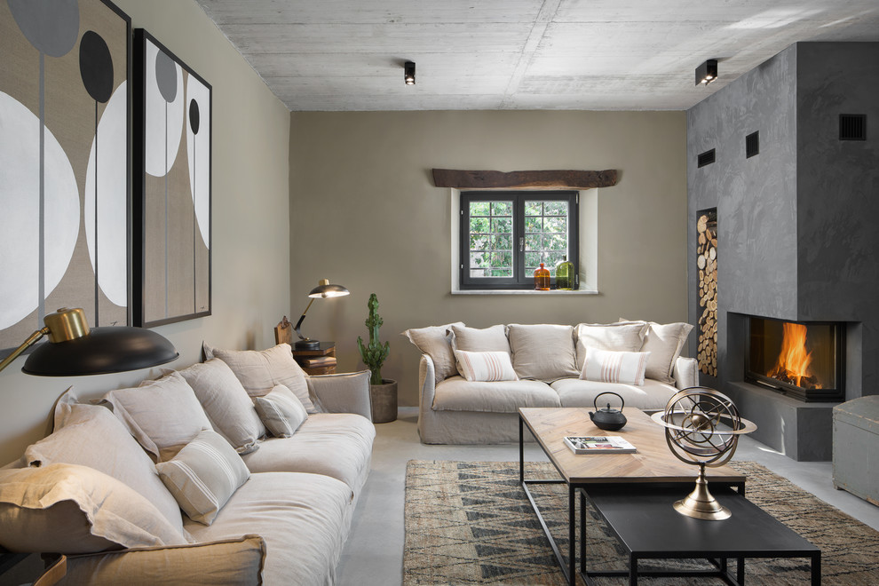 Aménagement d'une salle de séjour méditerranéenne avec un mur beige, sol en béton ciré, une cheminée standard et un sol gris.