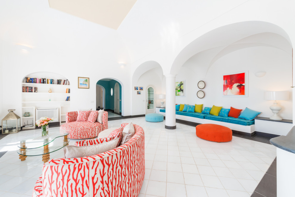 Aménagement d'un grand salon méditerranéen ouvert avec une salle de réception, un mur blanc, un sol en carrelage de porcelaine, un sol blanc et un plafond voûté.