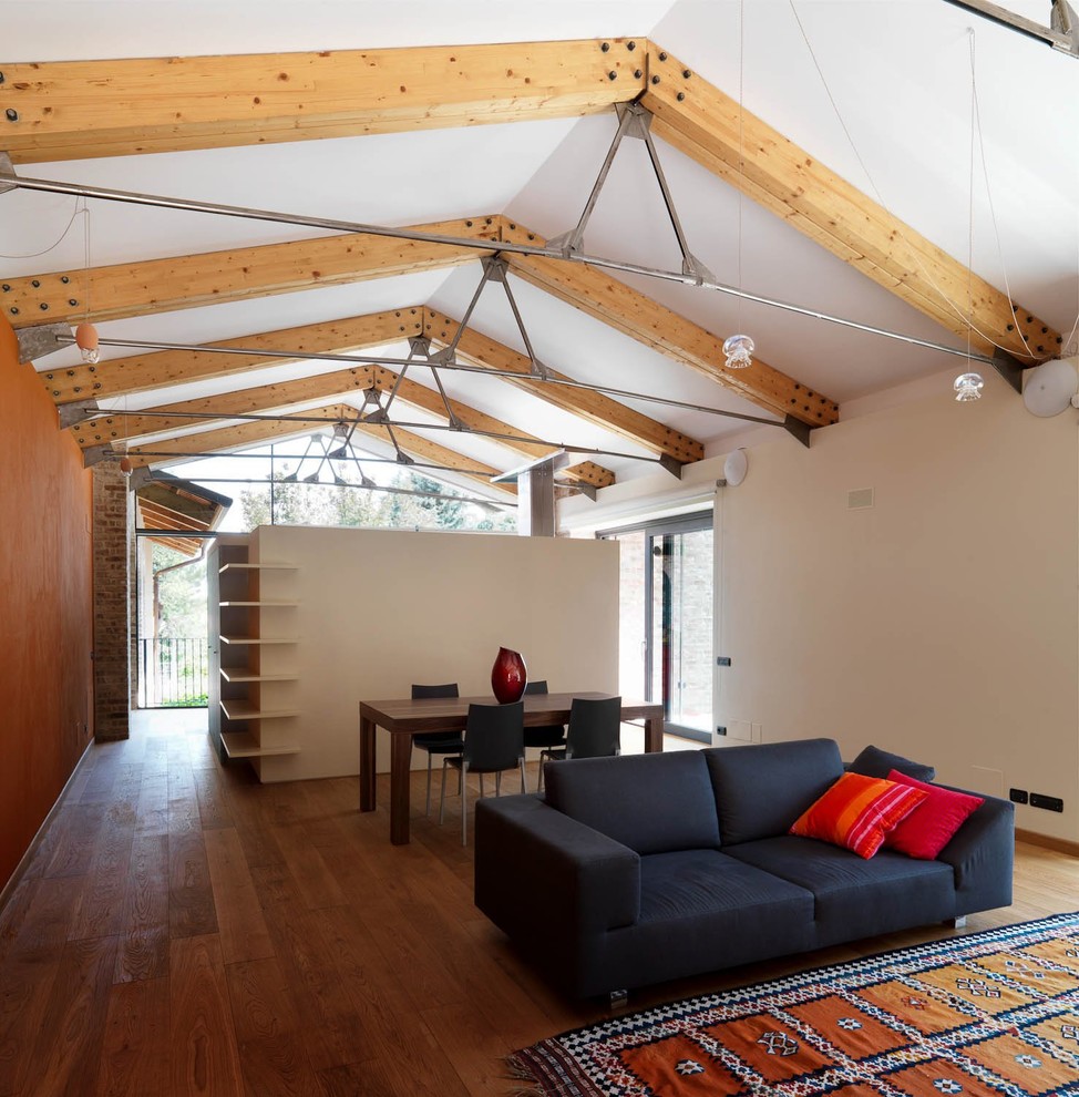 Idée de décoration pour une très grande salle de séjour mansardée ou avec mezzanine design avec un mur orange et un sol en bois brun.