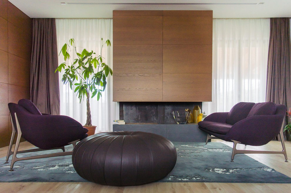 На фото: открытая гостиная комната среднего размера в современном стиле с коричневыми стенами, светлым паркетным полом, фасадом камина из дерева и ковром на полу с