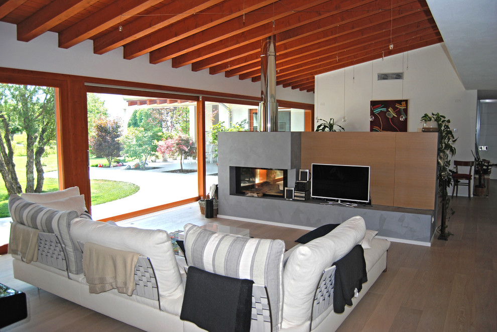 Esempio di un ampio soggiorno moderno aperto con libreria, pareti bianche, pavimento in legno verniciato, parete attrezzata e pavimento marrone