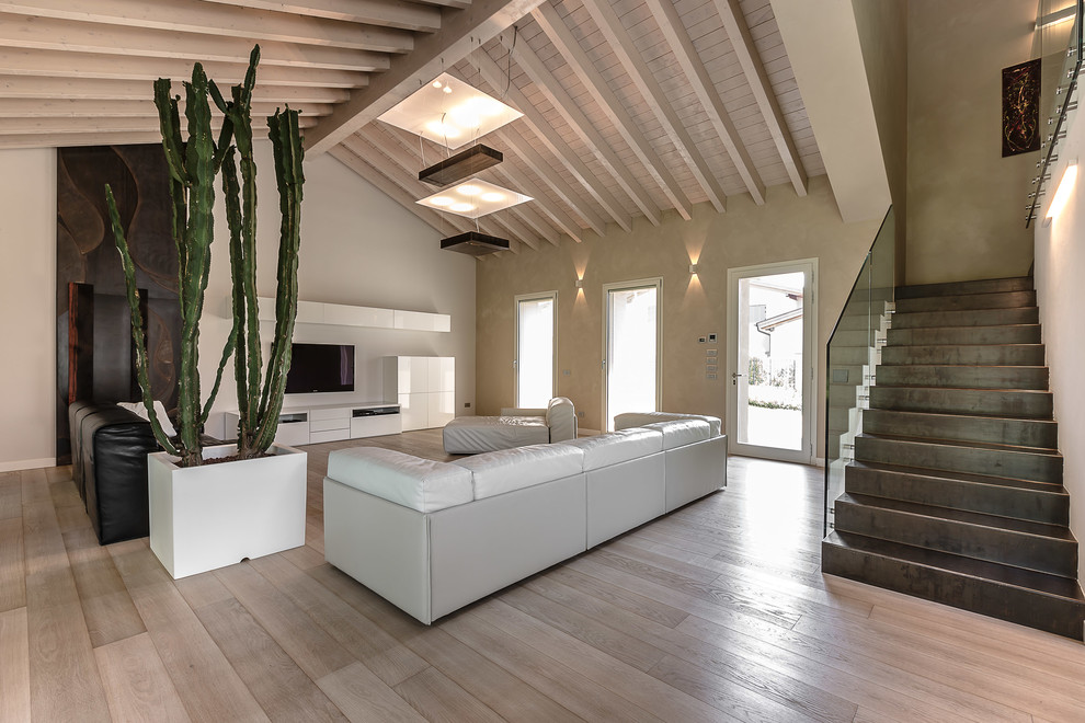 Свежая идея для дизайна: огромная гостиная комната в современном стиле с бежевыми стенами, светлым паркетным полом и телевизором на стене - отличное фото интерьера