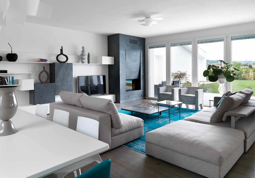 Ejemplo de sala de estar abierta contemporánea grande con paredes blancas, suelo de madera oscura, marco de chimenea de yeso y televisor independiente