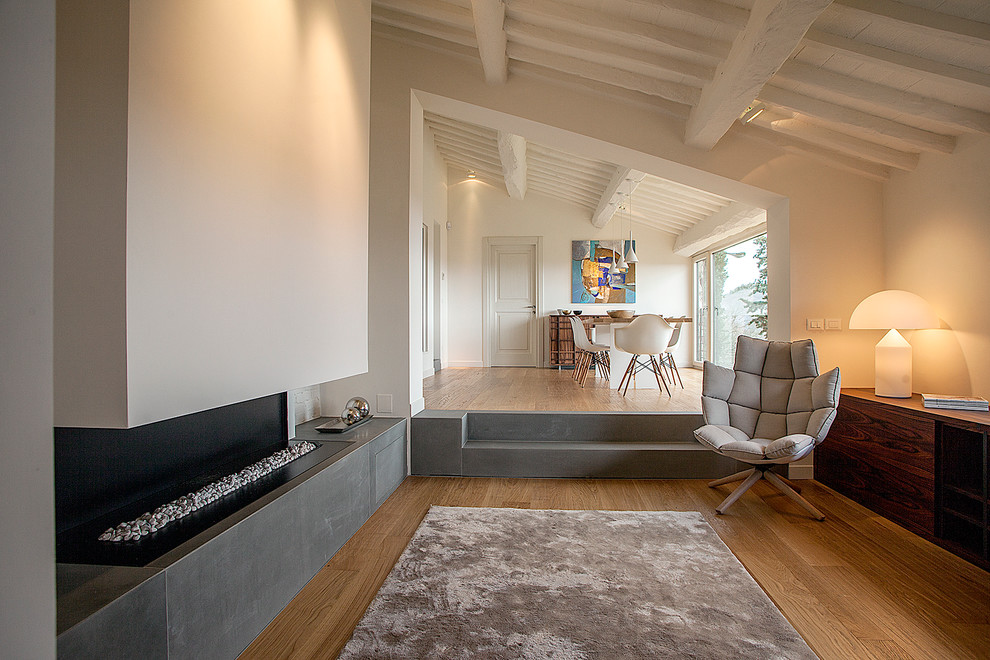Großes, Repräsentatives, Offenes Modernes Wohnzimmer mit weißer Wandfarbe, braunem Holzboden, Gaskamin und verputzter Kaminumrandung in Florenz
