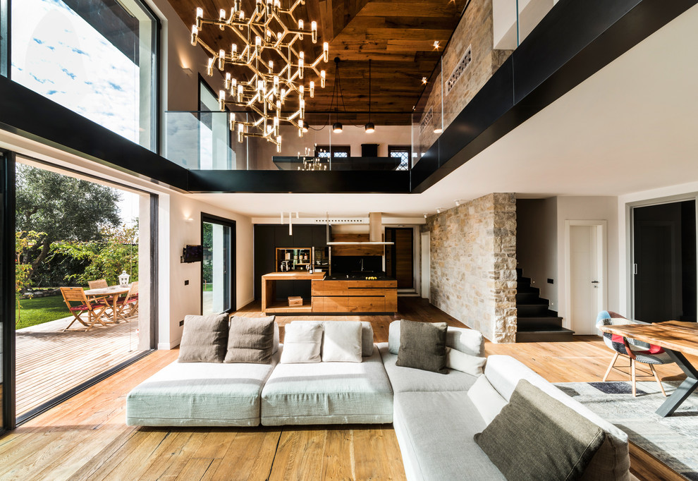 Geräumiges, Repräsentatives Modernes Wohnzimmer im Loft-Stil mit braunem Holzboden, weißer Wandfarbe, Kaminumrandung aus Holz und Multimediawand in Rom