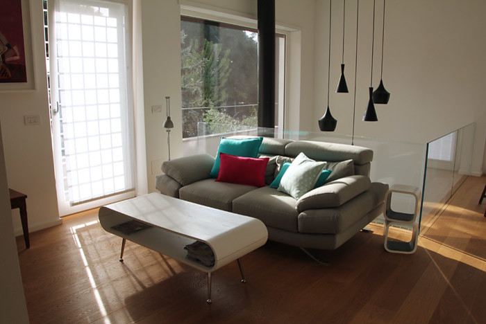 Cette image montre une salle de séjour design de taille moyenne et ouverte avec un mur blanc et un sol en bois brun.
