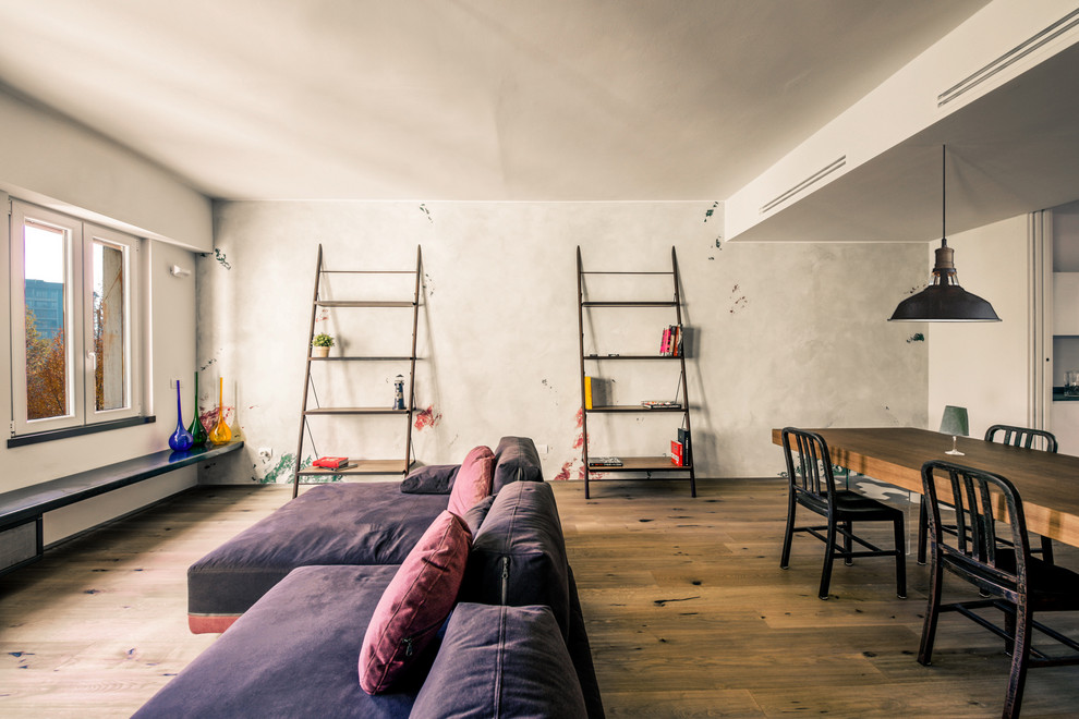 Идея дизайна: открытая гостиная комната среднего размера в стиле лофт с серыми стенами и светлым паркетным полом без камина