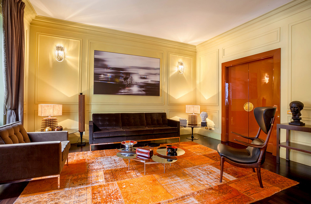На фото: гостиная комната в стиле неоклассика (современная классика) с желтыми стенами, темным паркетным полом и коричневым полом с