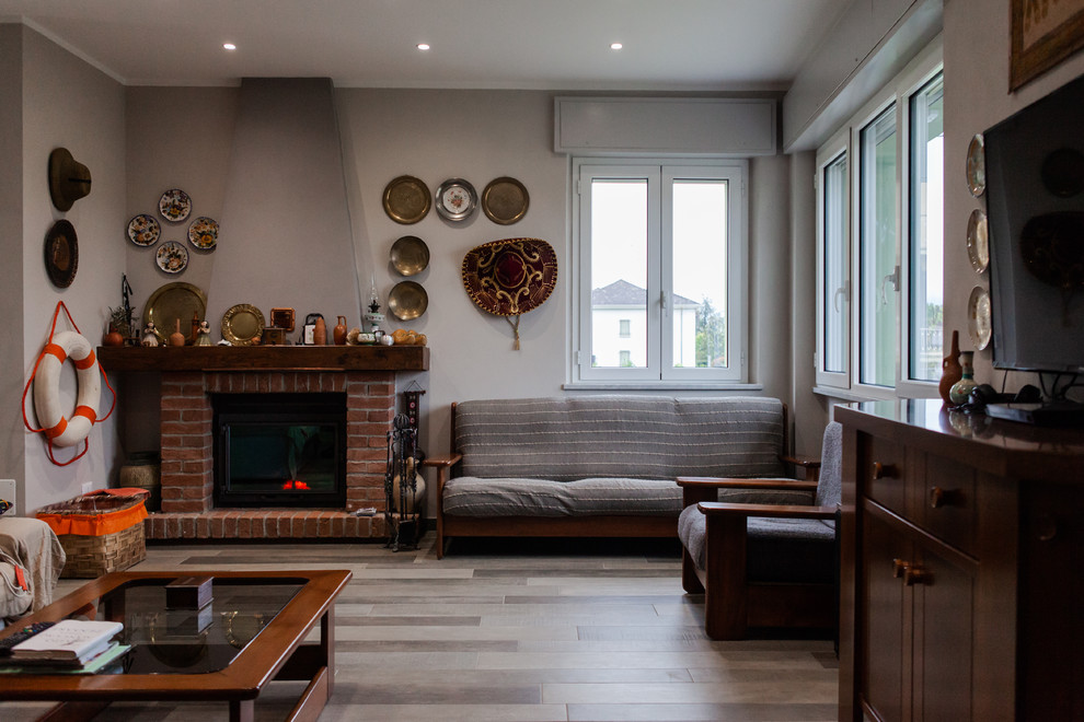 Foto di un soggiorno stile rurale di medie dimensioni e aperto con pareti grigie, pavimento in marmo, camino classico, cornice del camino in mattoni e pavimento marrone
