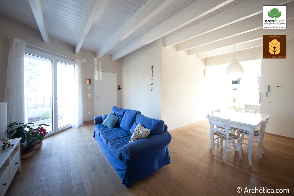 На фото: открытая гостиная комната среднего размера в современном стиле с белыми стенами, светлым паркетным полом и телевизором на стене без камина с
