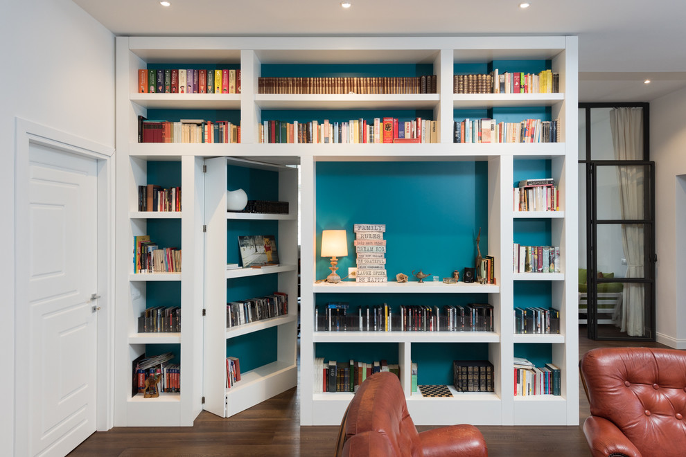 Esempio di un grande soggiorno moderno aperto con libreria, pareti bianche e parquet scuro