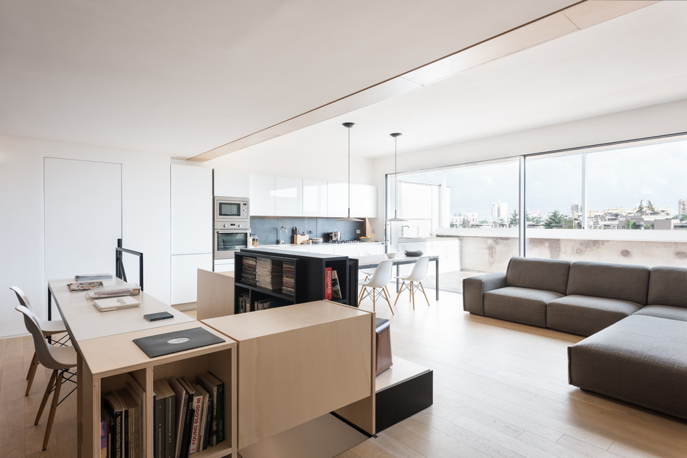 Foto di un soggiorno minimal stile loft con pareti bianche, parquet chiaro e libreria