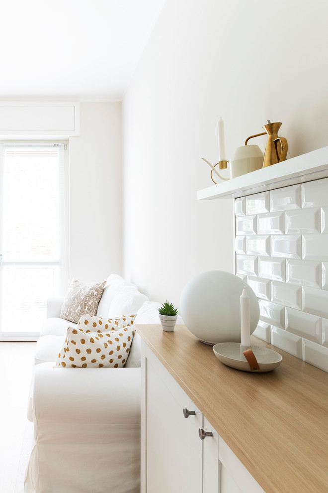 Inredning av ett minimalistiskt mellanstort loftrum, med beige väggar, ljust trägolv och en väggmonterad TV
