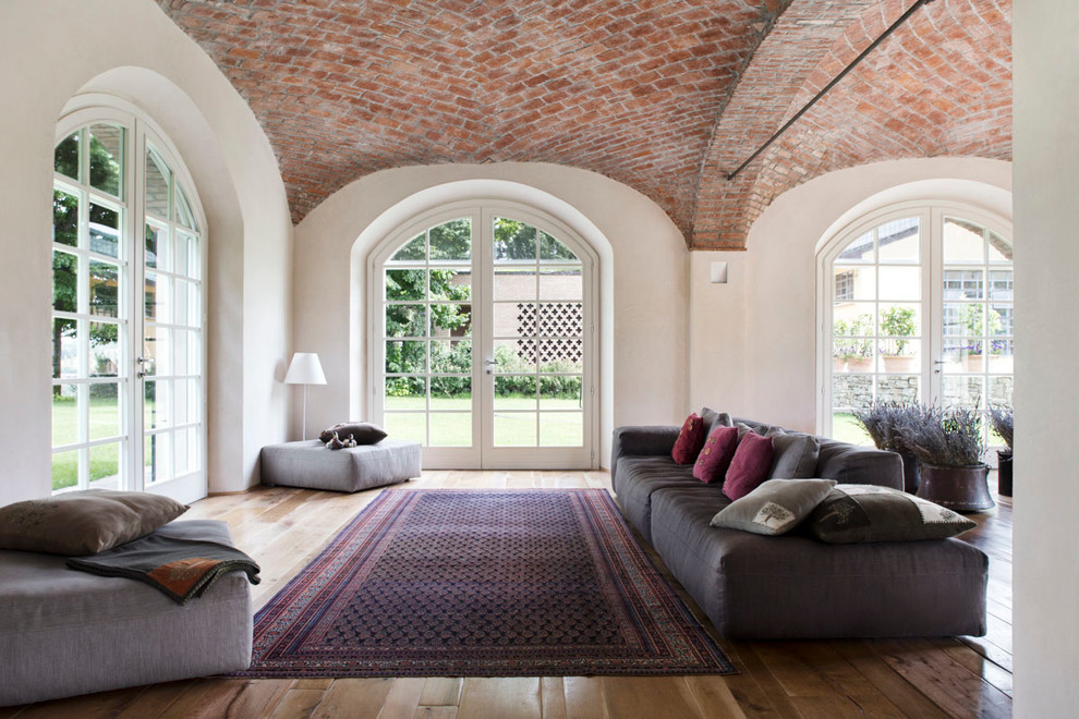Immagine di un ampio soggiorno country aperto con pareti bianche e pavimento in legno massello medio