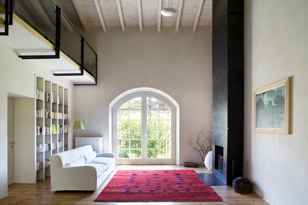 Foto de biblioteca en casa cerrada de estilo de casa de campo grande con paredes beige, suelo de madera clara, chimenea lineal y marco de chimenea de metal