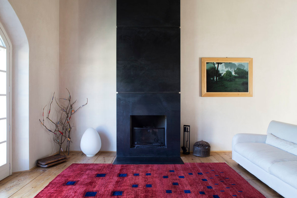Idee per un soggiorno minimalista con pareti bianche, parquet chiaro e camino classico