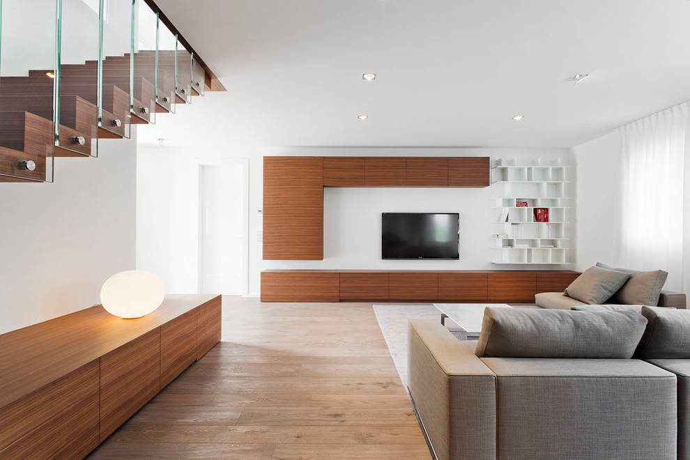 Ispirazione per un grande soggiorno minimal aperto con pareti bianche, parquet chiaro e TV a parete