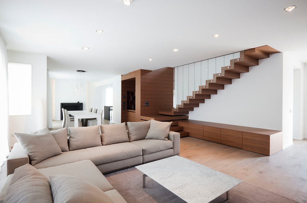 Esempio di un grande soggiorno design aperto con pareti bianche e parquet chiaro