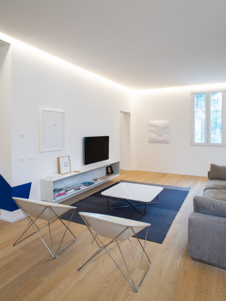 Immagine di un grande soggiorno minimal aperto con pareti bianche, parquet chiaro, TV a parete, pavimento beige e soffitto a cassettoni