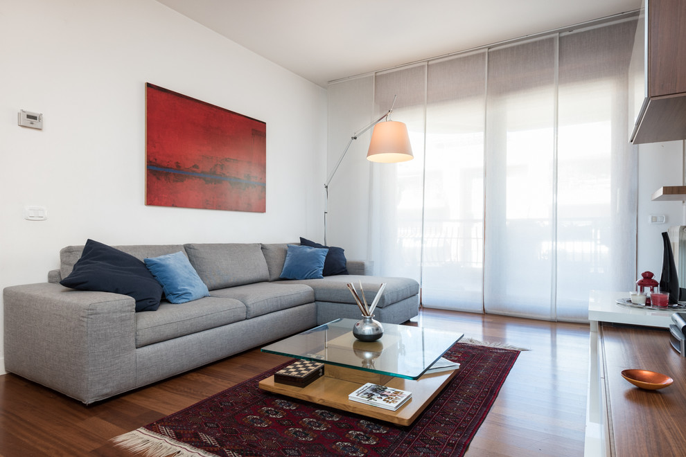 Ispirazione per un soggiorno moderno aperto con pareti bianche, pavimento in legno massello medio, nessun camino e TV a parete