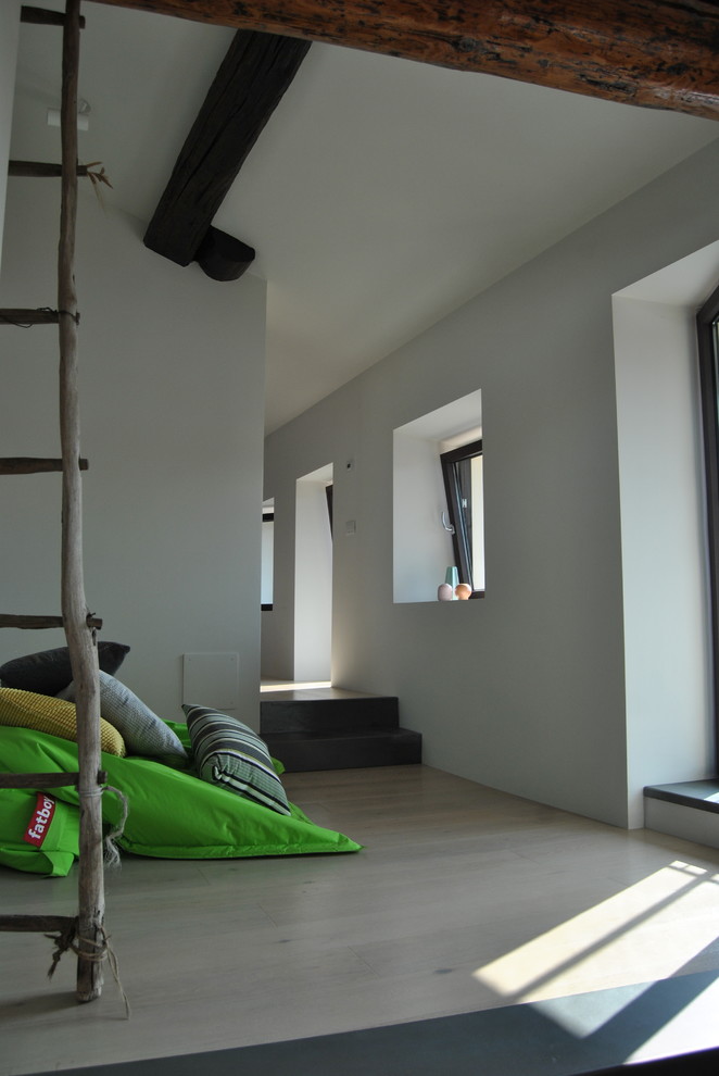 Ejemplo de sala de estar abierta actual pequeña con paredes blancas, suelo de madera clara y suelo beige