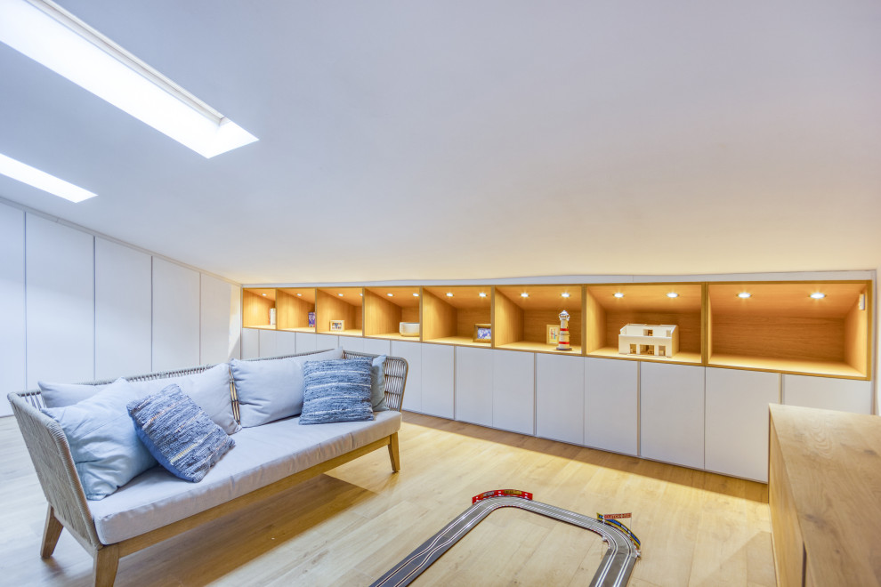 This is an example of a large scandi look-out basement in Other with white walls and light hardwood flooring.