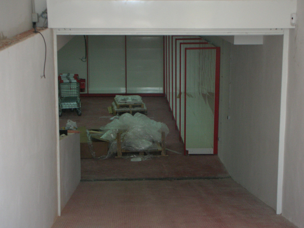 Foto de sótano con ventanas contemporáneo extra grande con paredes blancas, suelo de cemento y suelo rojo