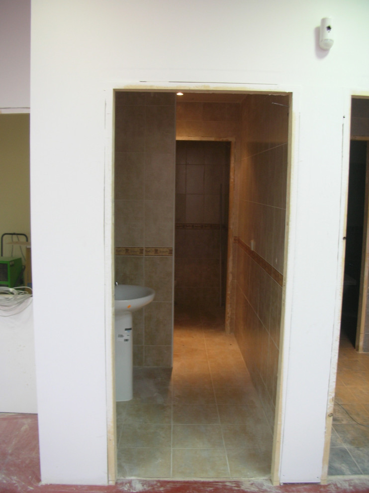 Imagen de sótano con ventanas contemporáneo extra grande con paredes blancas, suelo de cemento y suelo rojo