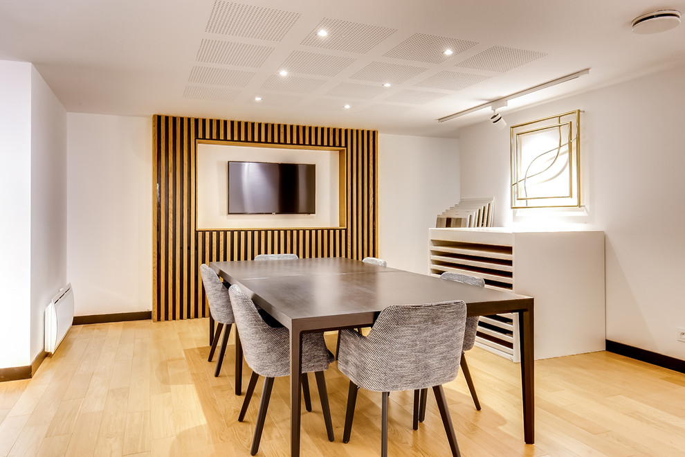 Mittelgroßer Moderner Keller mit weißer Wandfarbe, hellem Holzboden und braunem Boden in Paris