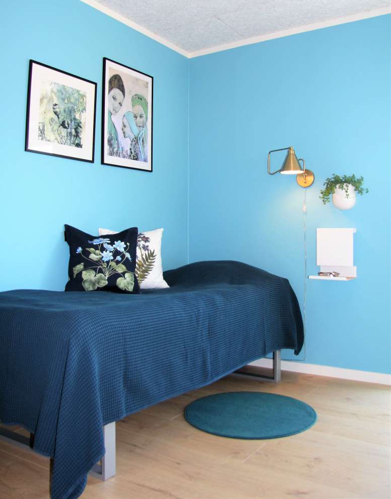 Idée de décoration pour une chambre minimaliste avec un mur bleu, sol en stratifié et un sol beige.