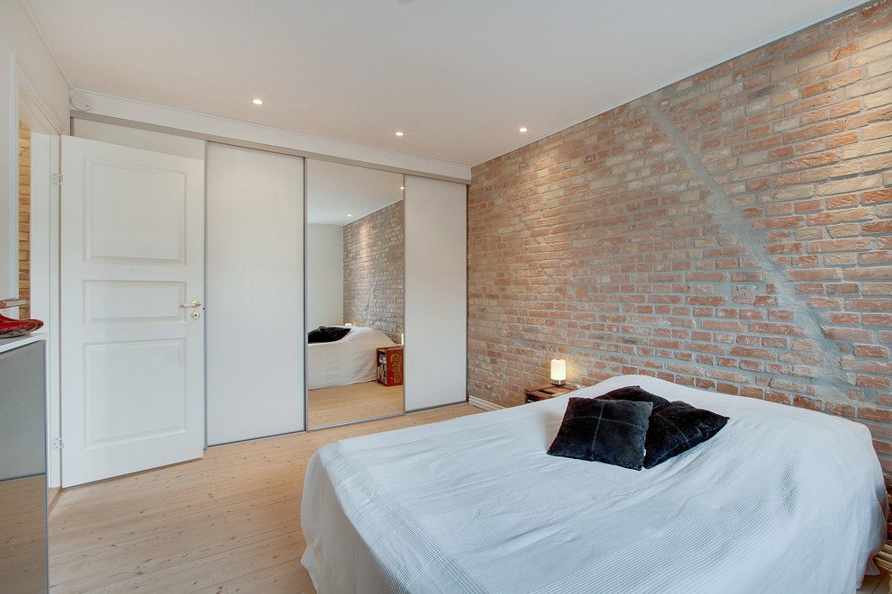 На фото: большая хозяйская спальня в скандинавском стиле с белыми стенами и светлым паркетным полом без камина с