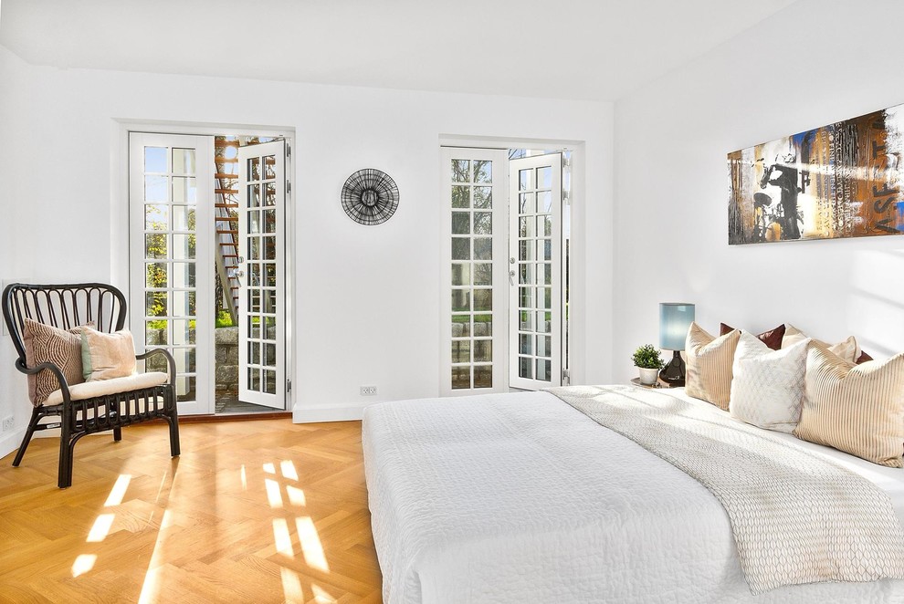 Foto på ett minimalistiskt sovrum, med vita väggar, mellanmörkt trägolv och brunt golv