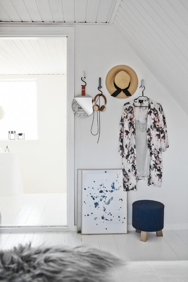 Kleines Skandinavisches Schlafzimmer mit weißer Wandfarbe und gebeiztem Holzboden in Wiltshire
