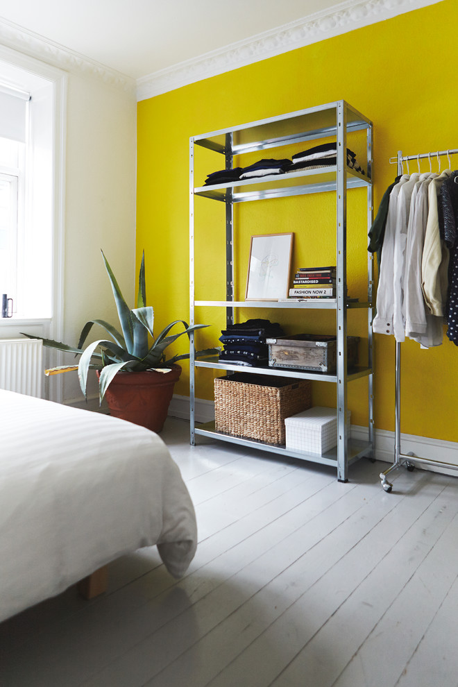 ウィルトシャーにある中くらいな北欧スタイルのおしゃれな寝室 (黄色い壁、塗装フローリング、白い床)