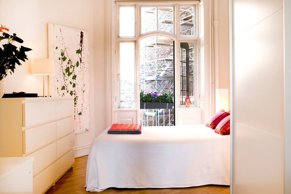 На фото: хозяйская спальня среднего размера в современном стиле с белыми стенами и светлым паркетным полом без камина