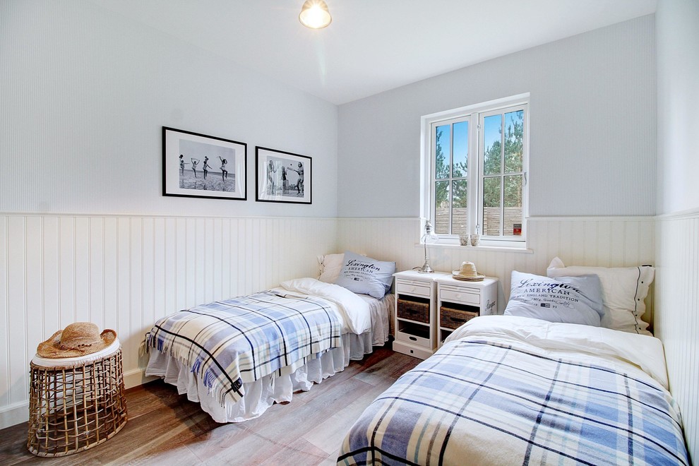 Photo of a medium sized coastal guest bedroom in Copenhagen with medium hardwood flooring, brown floors and blue walls.