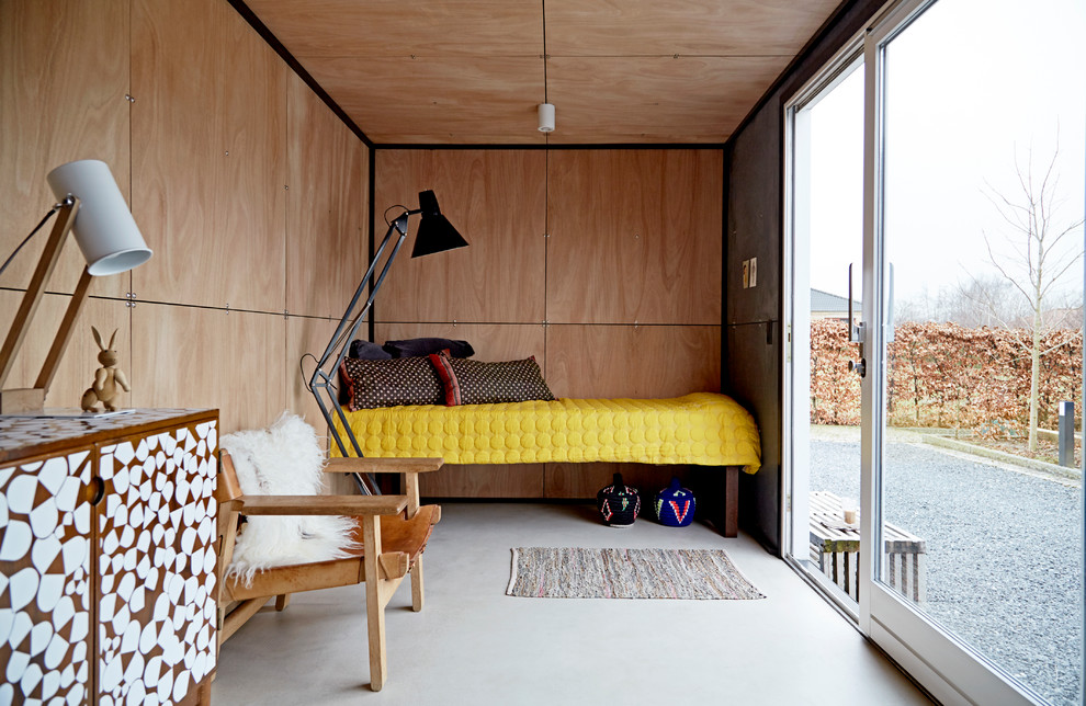 На фото: маленькая спальня в скандинавском стиле с бетонным полом и серым полом без камина для на участке и в саду с