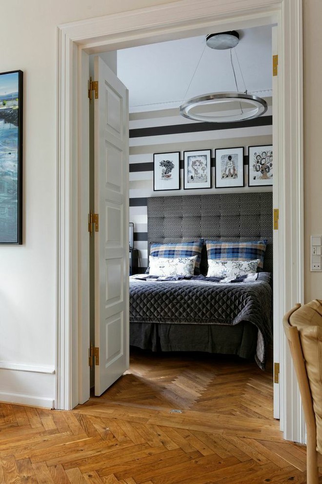 Ispirazione per una camera da letto nordica con pareti multicolore, pavimento in legno massello medio e pavimento marrone