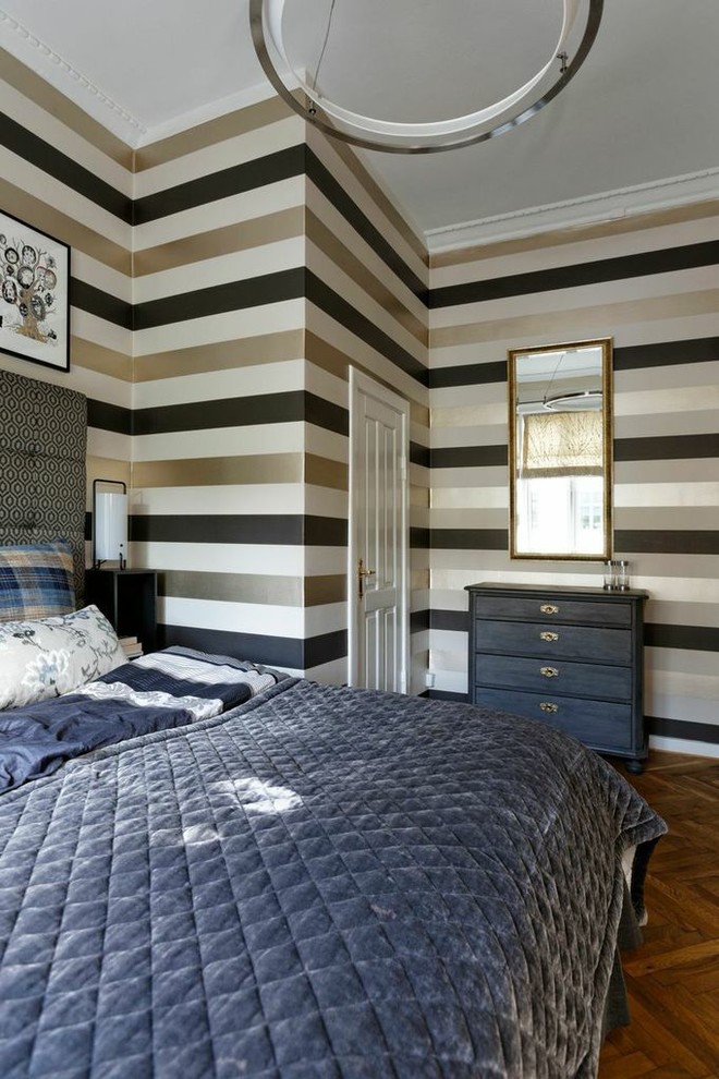 Photo of a modern bedroom in Copenhagen with multi-coloured walls, medium hardwood flooring and brown floors.