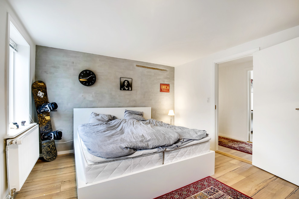 Imagen de dormitorio principal nórdico con suelo de madera clara, paredes grises y suelo marrón