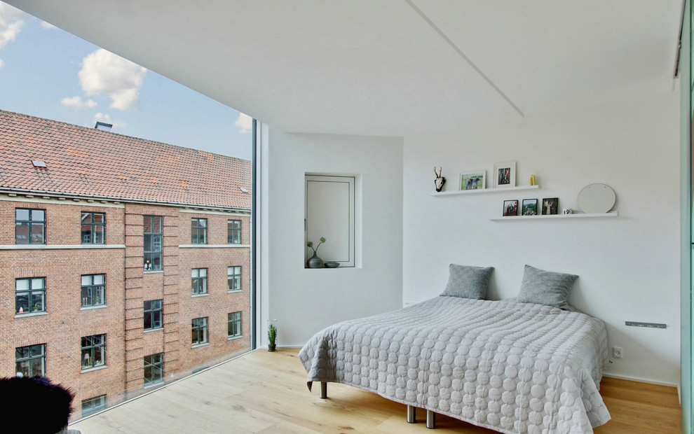Пример оригинального дизайна: большая хозяйская спальня в скандинавском стиле с белыми стенами и светлым паркетным полом