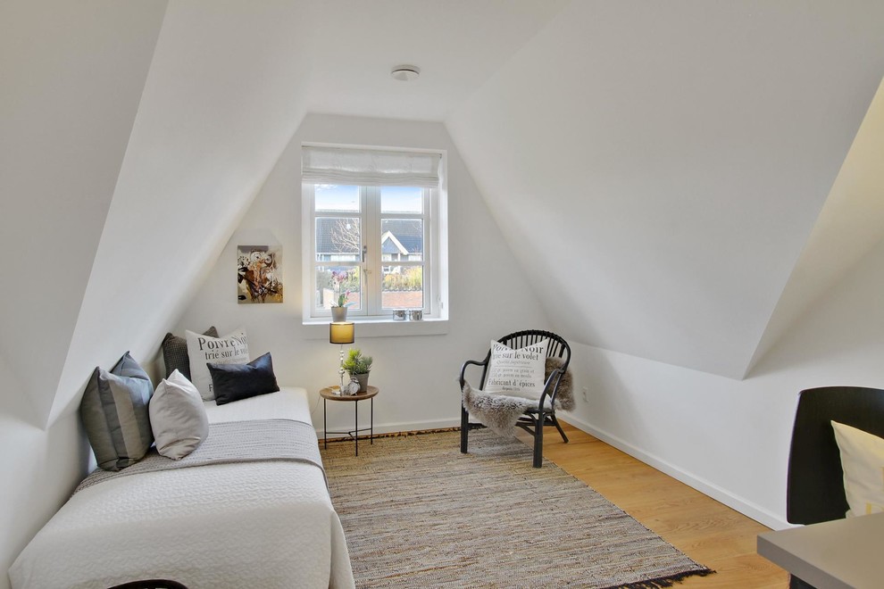 Ejemplo de habitación de invitados escandinava pequeña con paredes blancas, suelo de madera en tonos medios y suelo marrón