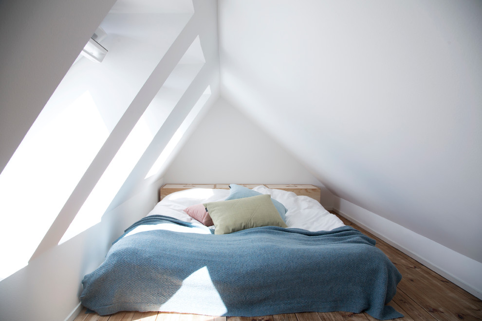 Mittelgroßes Nordisches Schlafzimmer ohne Kamin mit weißer Wandfarbe und braunem Holzboden in Kopenhagen