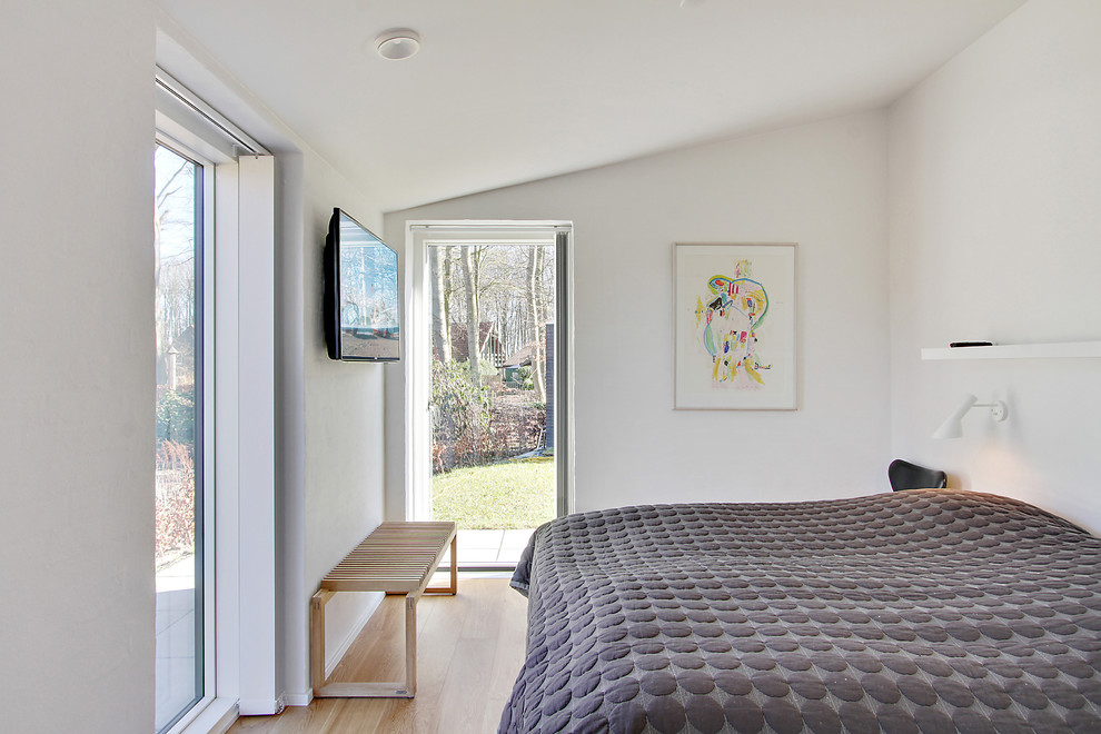 Inspiration för minimalistiska sovrum, med ljust trägolv och beiget golv