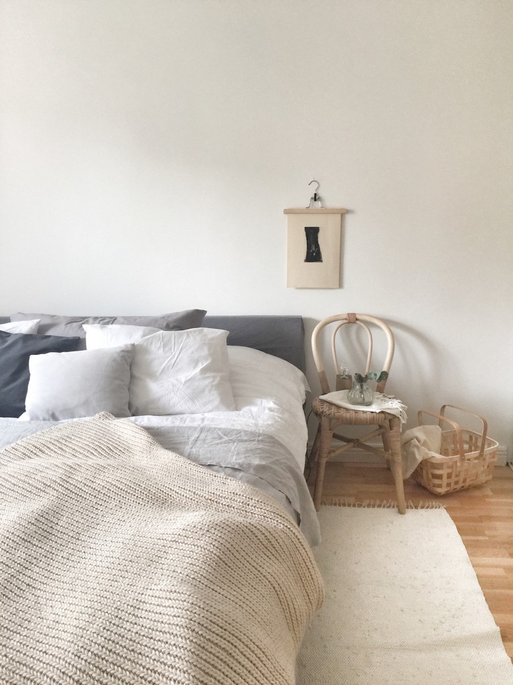 Kleines Nordisches Hauptschlafzimmer mit weißer Wandfarbe und hellem Holzboden in Stockholm