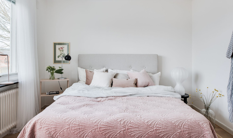 Kleines Skandinavisches Schlafzimmer mit weißer Wandfarbe und hellem Holzboden in Göteborg