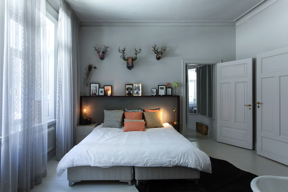 На фото: большая хозяйская спальня в стиле фьюжн с белыми стенами, деревянным полом и кроватью в нише без камина с