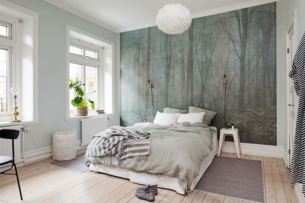 На фото: большая хозяйская спальня в скандинавском стиле с светлым паркетным полом и синими стенами без камина