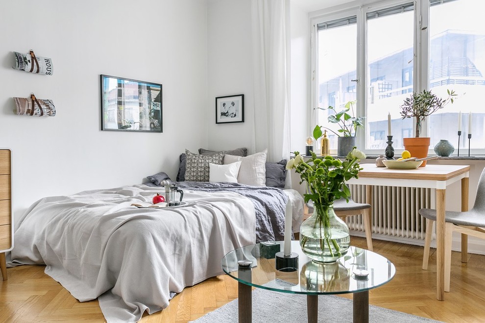 Small scandinavian bedroom in Stockholm with brown floors.